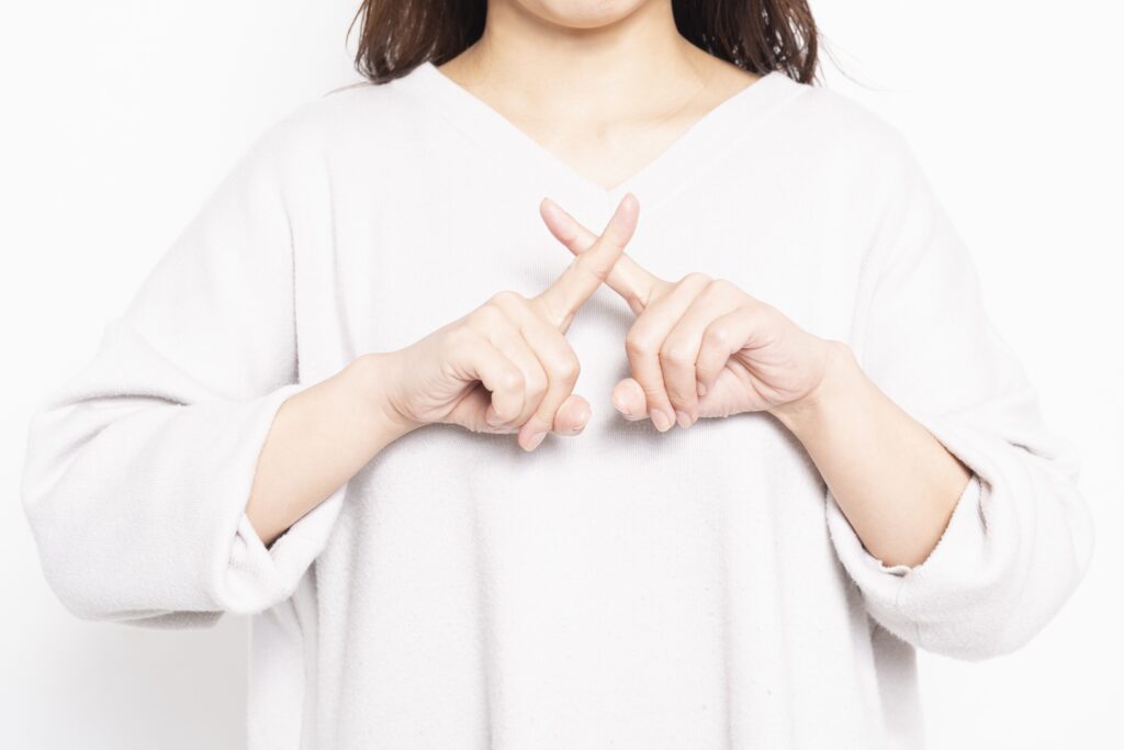 NGのサインを作る女性