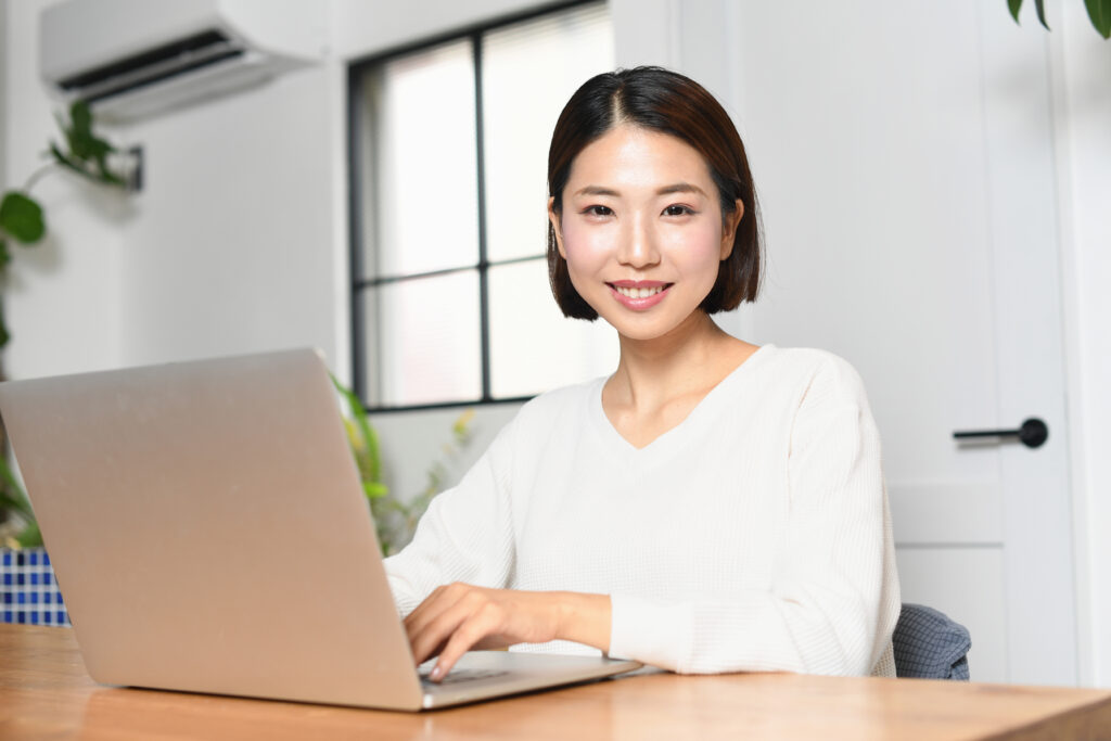 ノートパソコンと笑顔の若い女性