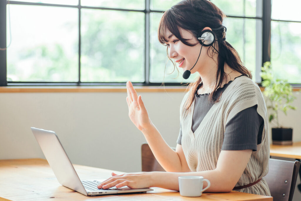 ヘッドセットをつけてパソコンを使う女性