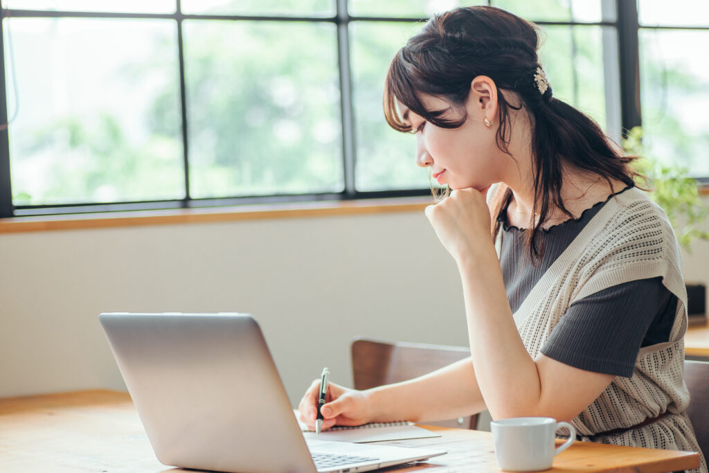 おしゃれ空間で勉強する女性(笑顔)