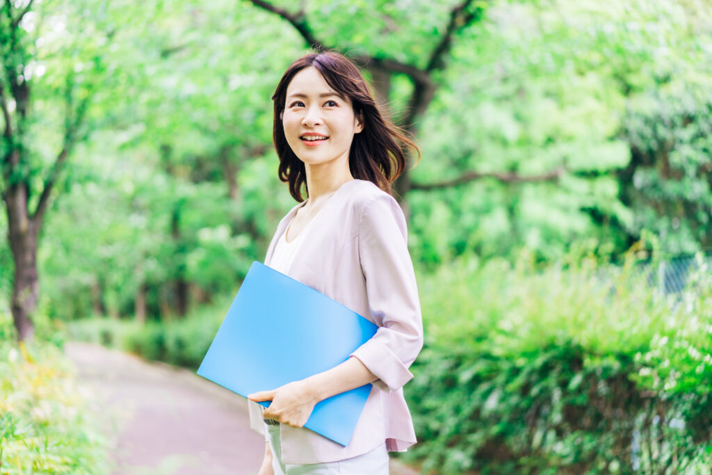書類を持って歩く若いビジネスウーマン