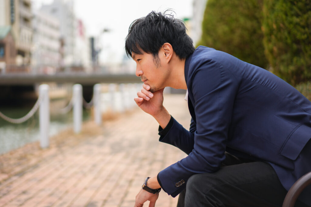ベンチで考える男性