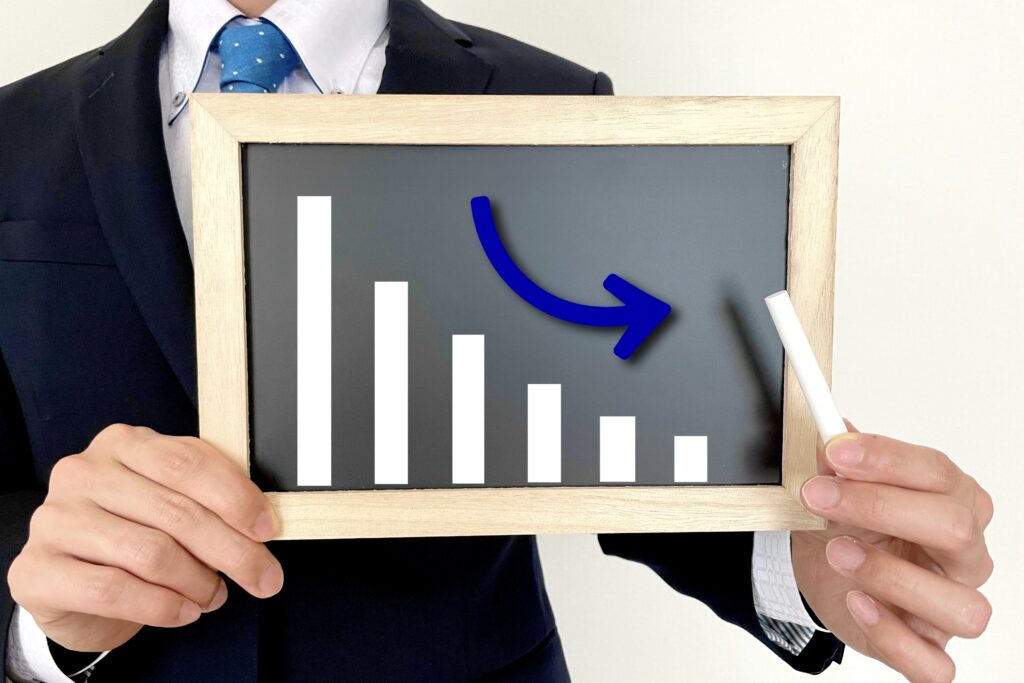 下がるグラフを持つサラリーマン