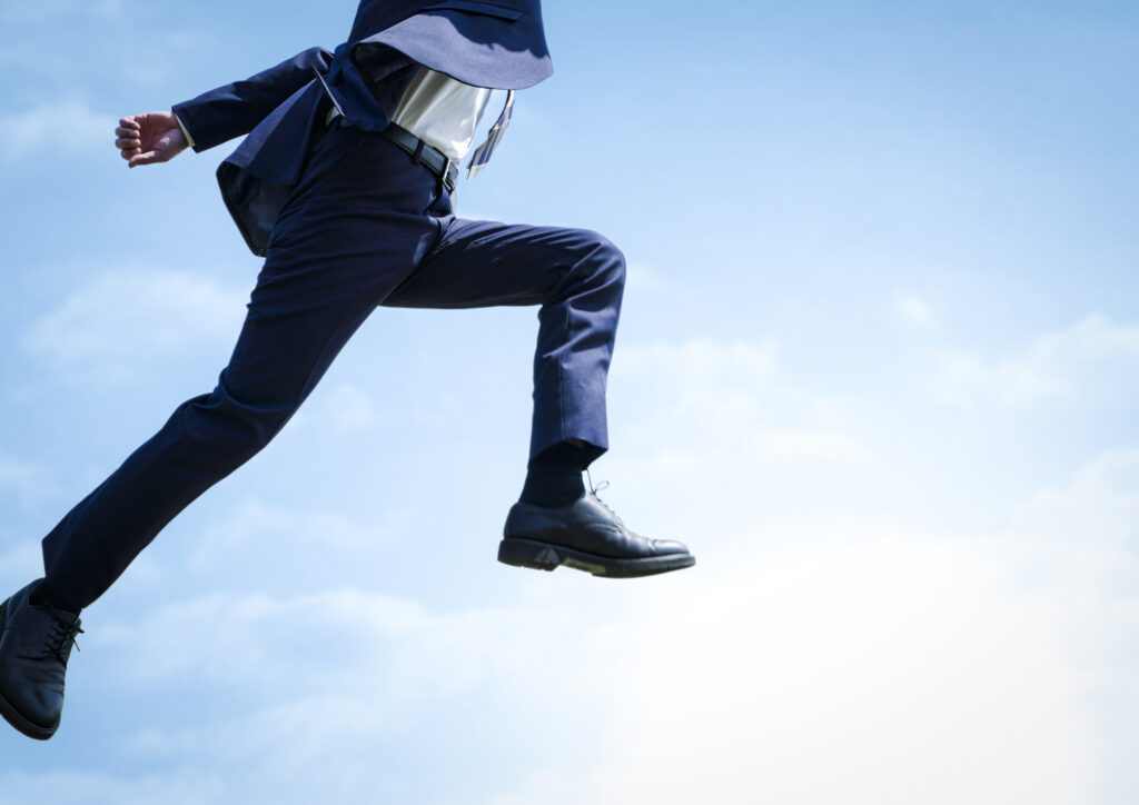 ジャンプするビジネスマン空背景