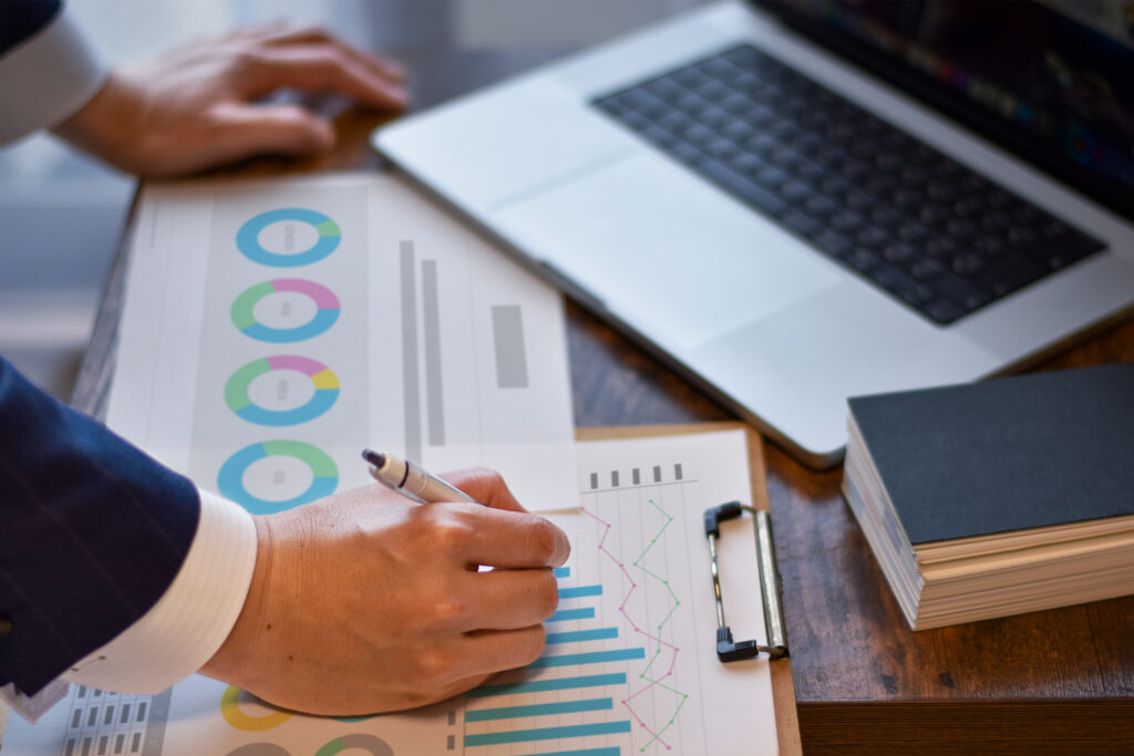 デスクで資料に書き込みしている男性