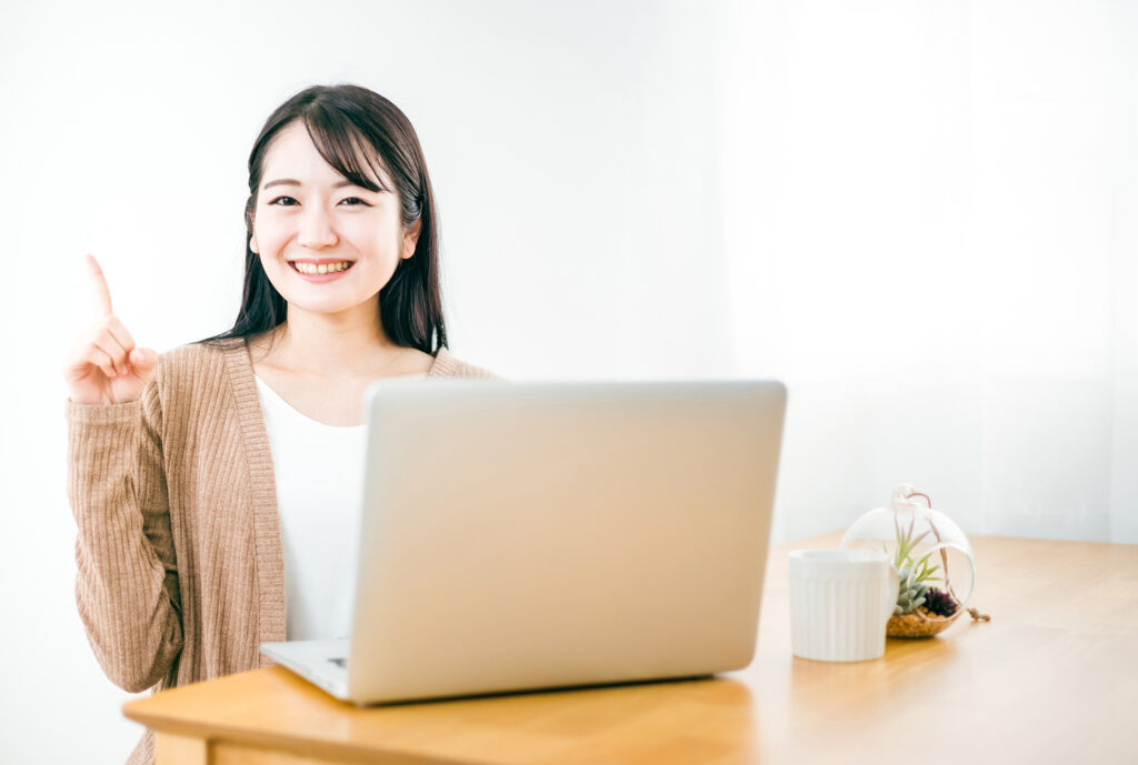 家でノートパソコンを使う女性