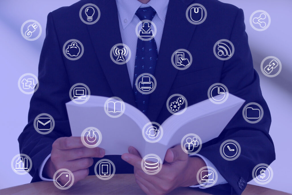 手に本を持つスーツのビジネスマン