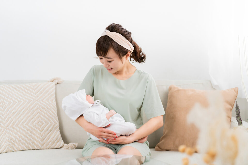 出産して赤ちゃんを抱っこする産休中の女性