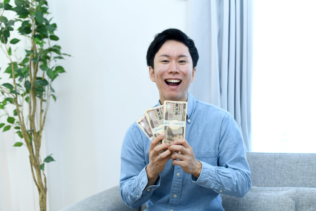 札束を持つ笑顔の男性