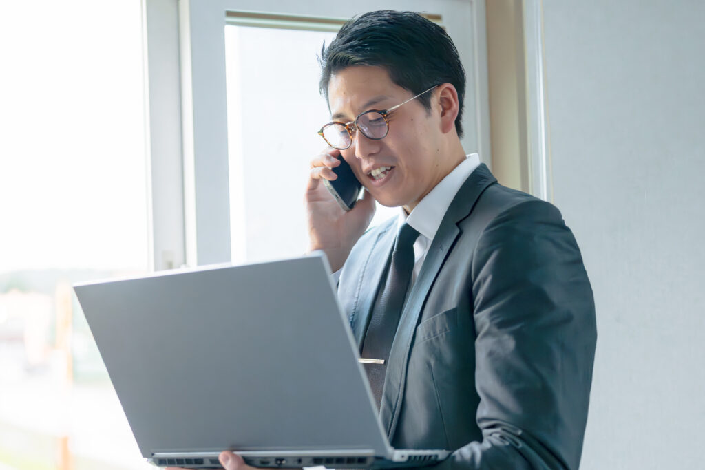電話とPCとスーツ男性