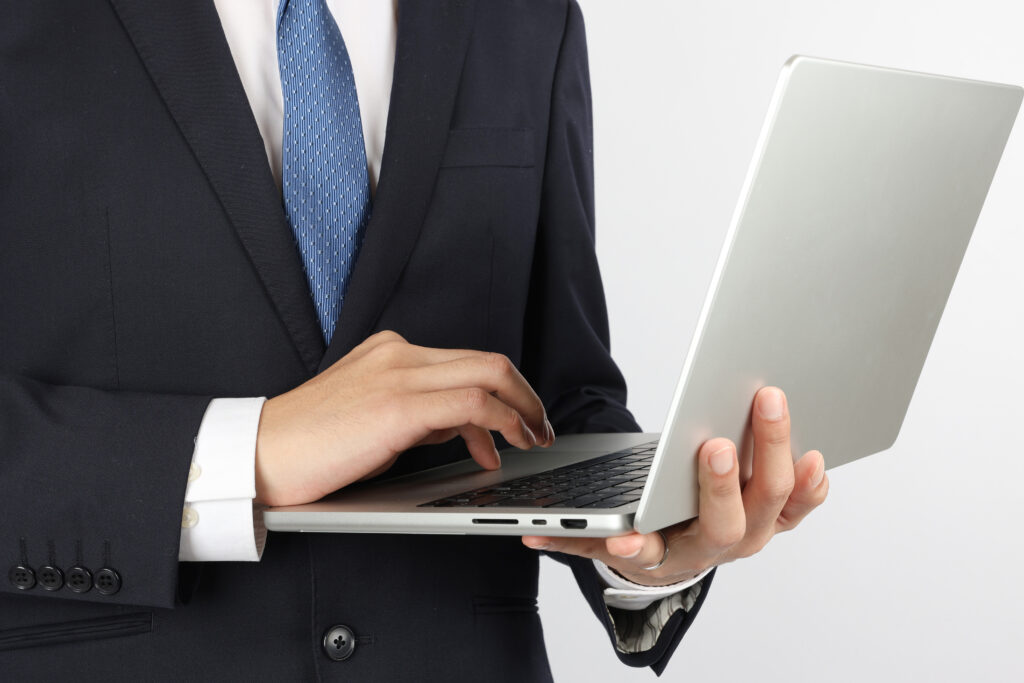 パソコンを操作するビジネスマンの手UP