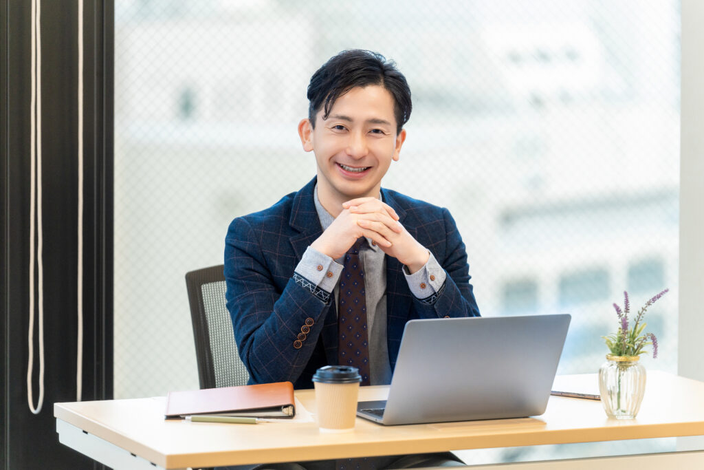 パソコンを使う笑顔の男性ビジネスマン