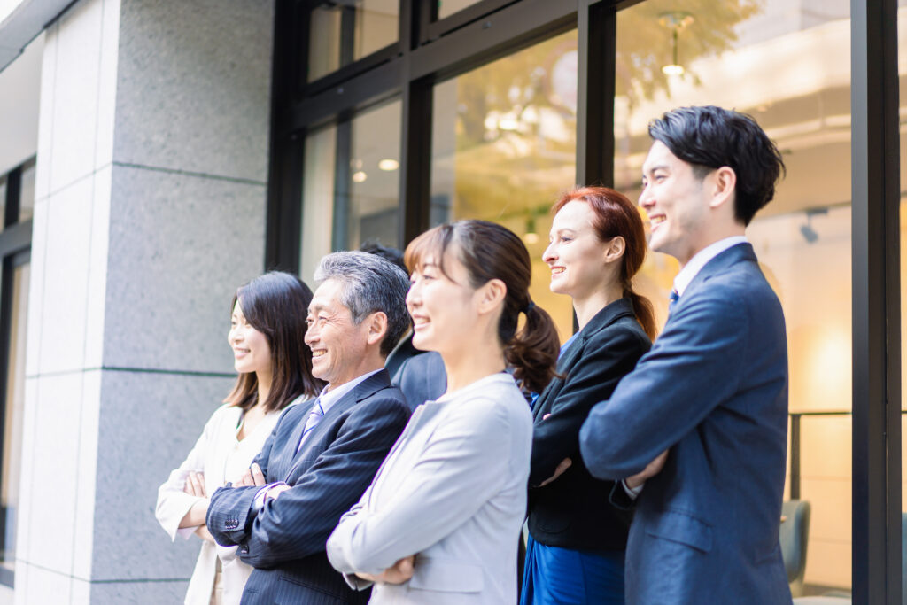 オフィスの前で腕を組むビジネスパーソン