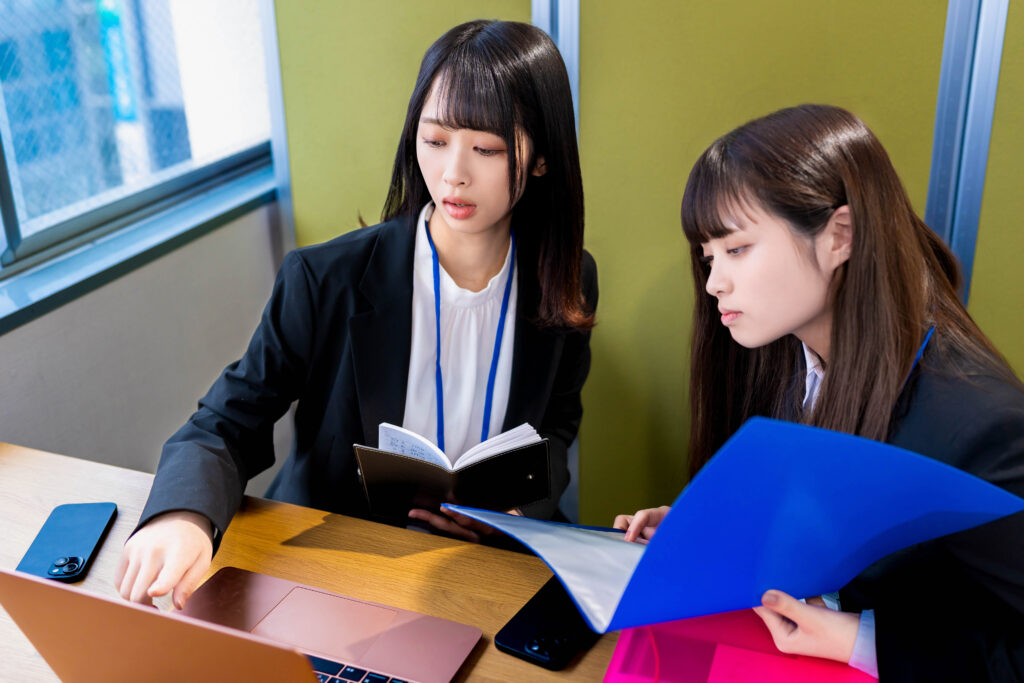 パソコンを指差して打ち合わせする女性