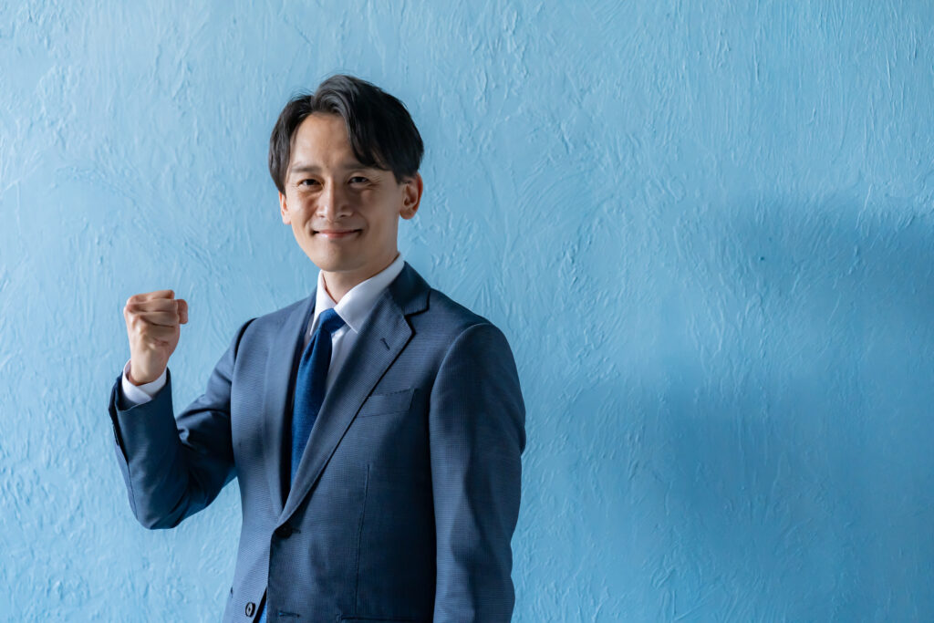 ガッツポーズをするスーツを着た男性