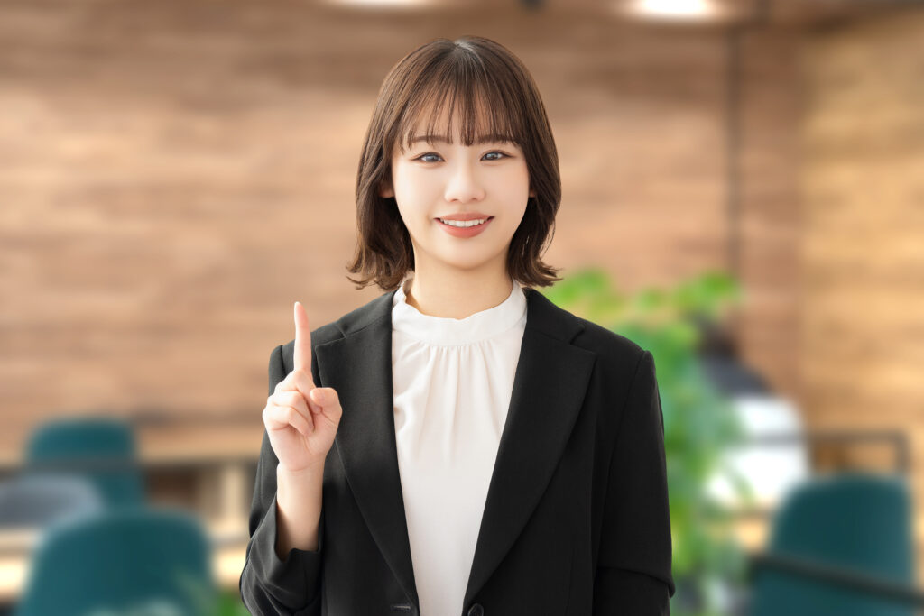 人差し指を立てて案内する笑顔の女性