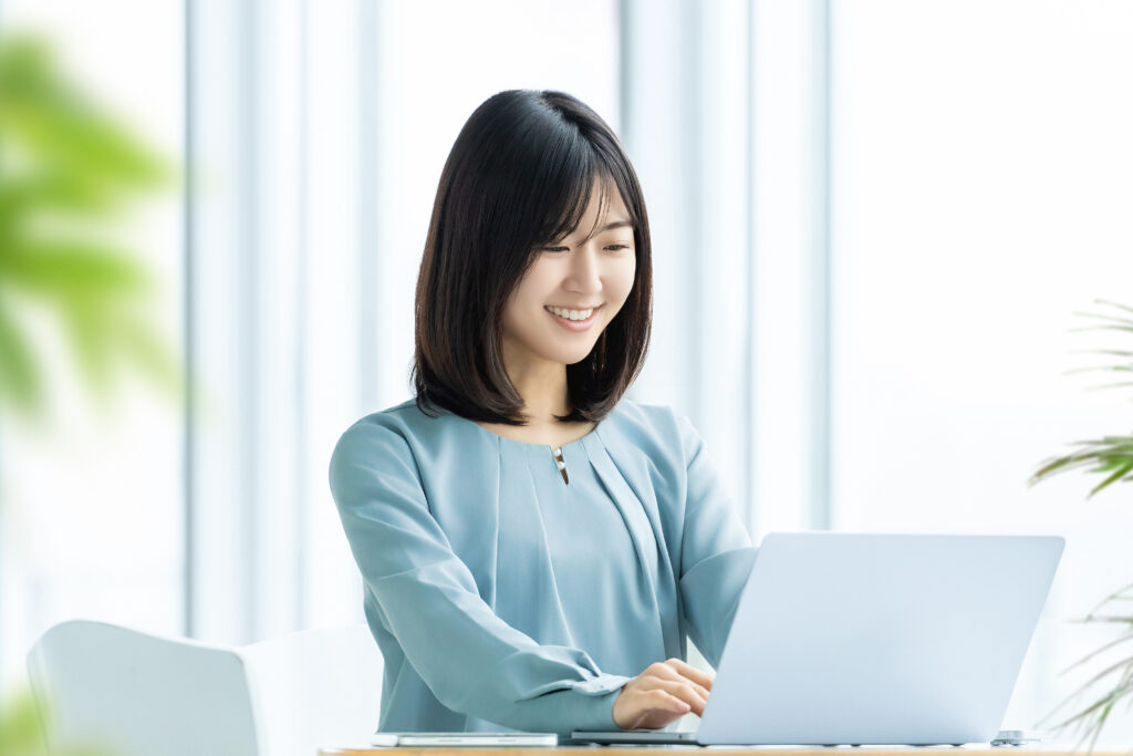 ノートパソコンを使う笑顔の女性