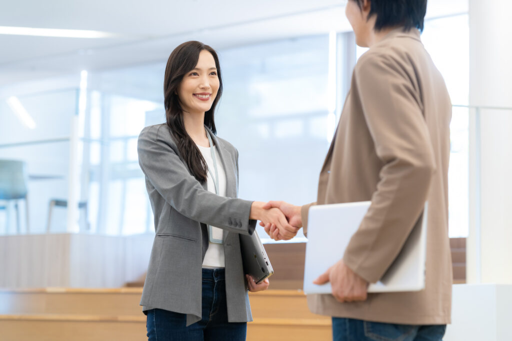 握手をする男女のビジネスマン
