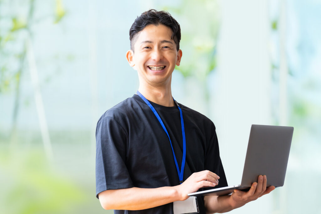 ノートパソコンを持つ笑顔のビジネスマン