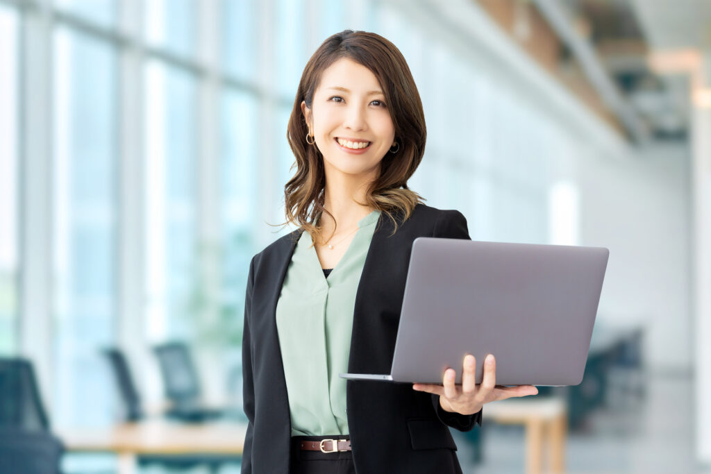 パソコンを持つ笑顔のビジネスウーマン