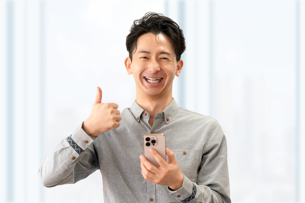 スマホを持っていいね!のポーズをする男性