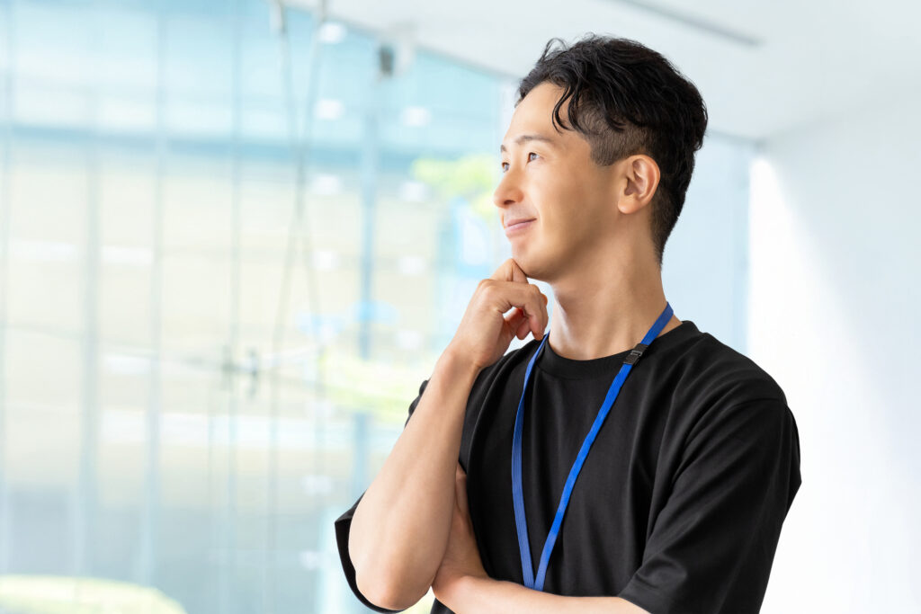 考えごとをする笑顔の男性ビジネスマン