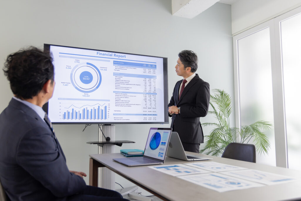 大画面モニターで説明するミドルエイジ男性