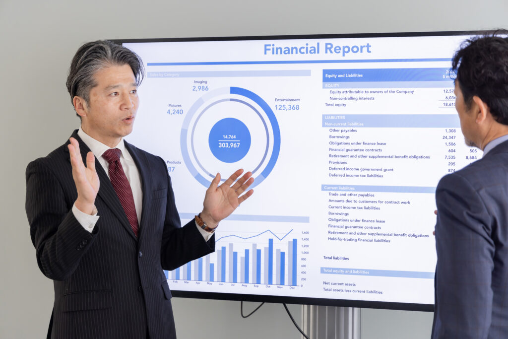 大画面モニターで説明するミドルエイジ男性