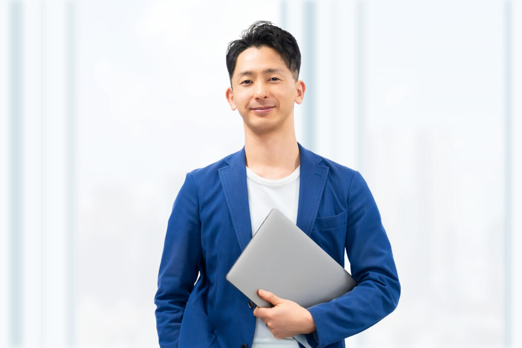 パソコンを持つ笑顔の男性ビジネスマン