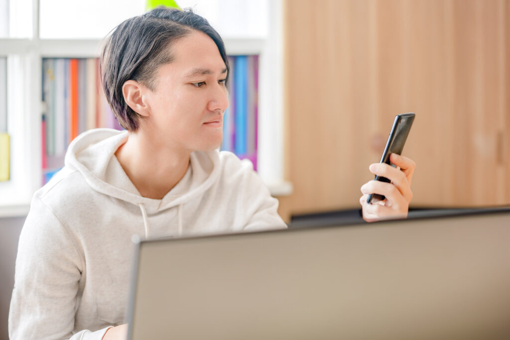 笑顔でスマホを見る男性