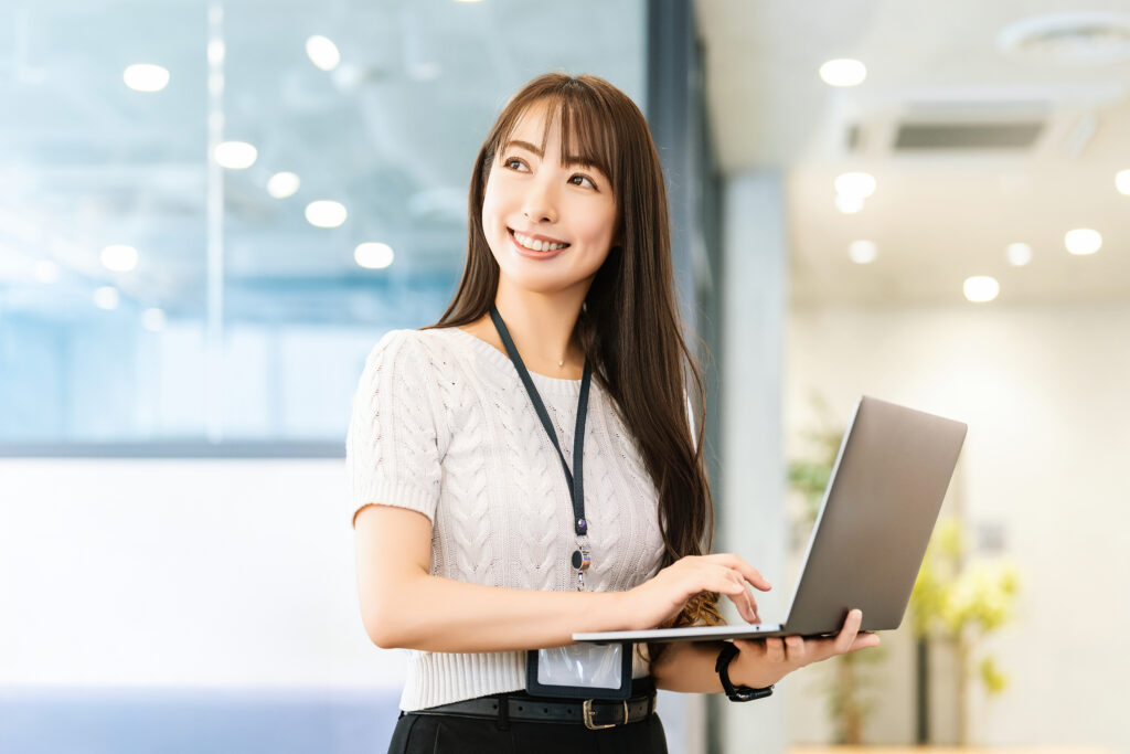 オフィスでパソコンを使う笑顔の女性