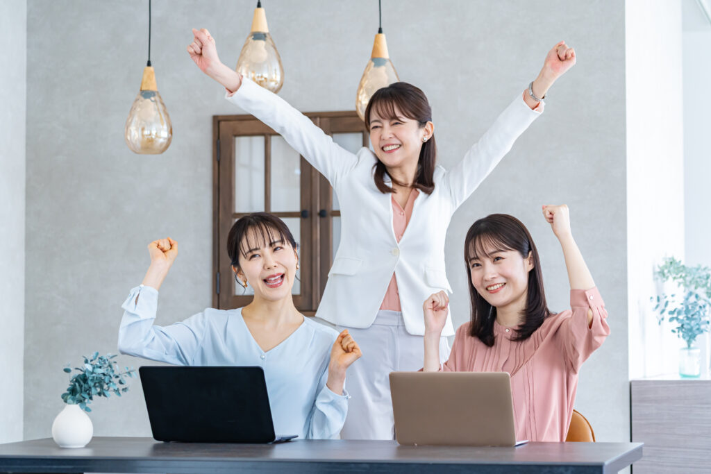 ガッツポーズをする私服の女性3人