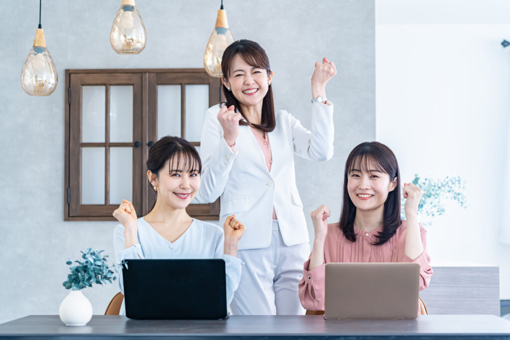 ガッツポーズをする私服の女性3人