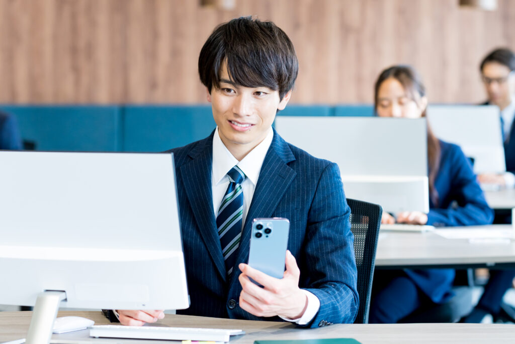 オフィスでスマホを持つビジネスマン