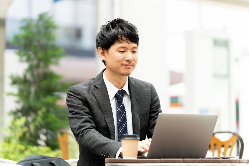 テラス席でパソコンを使う男性