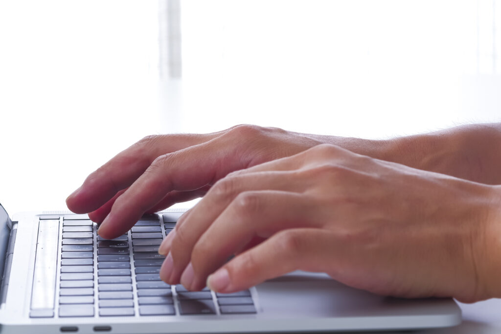 パソコンをタイピングする手のアップ