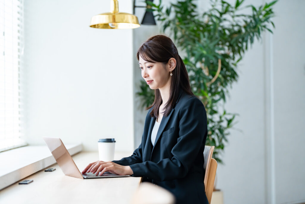 室内でパソコン作業をするスーツを着た女性