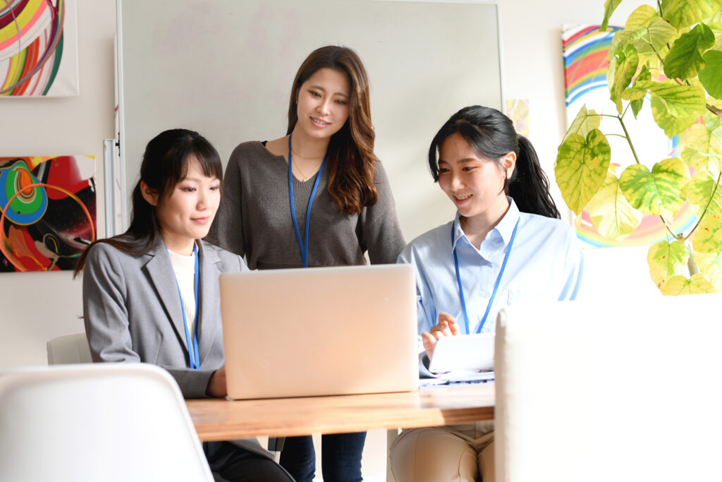 パソコンの前で打ち合わせをする若い女性達