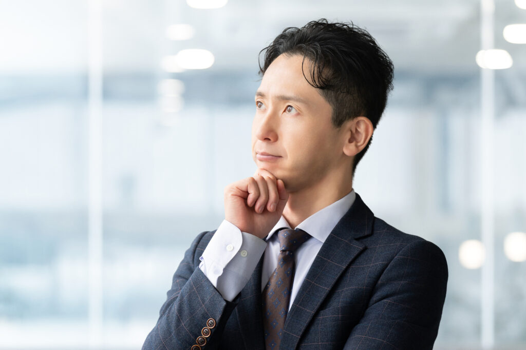考えごとをする男性ビジネスマン