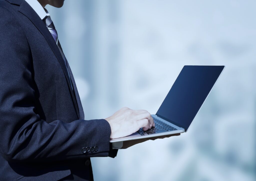 ノートPCを持つ横向きビジネスマン