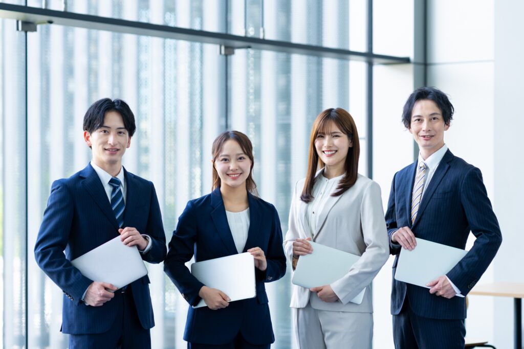 パソコンを持った4人組エンジニア