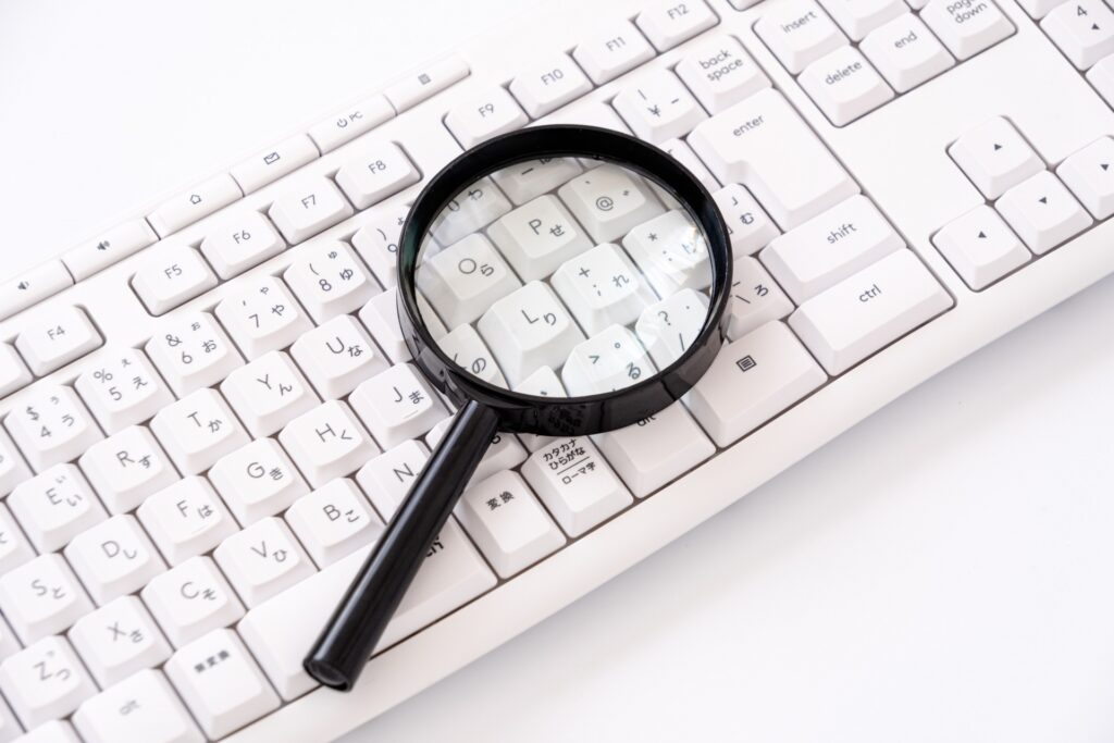 虫眼鏡とパソコンでリサーチや検索イメージ