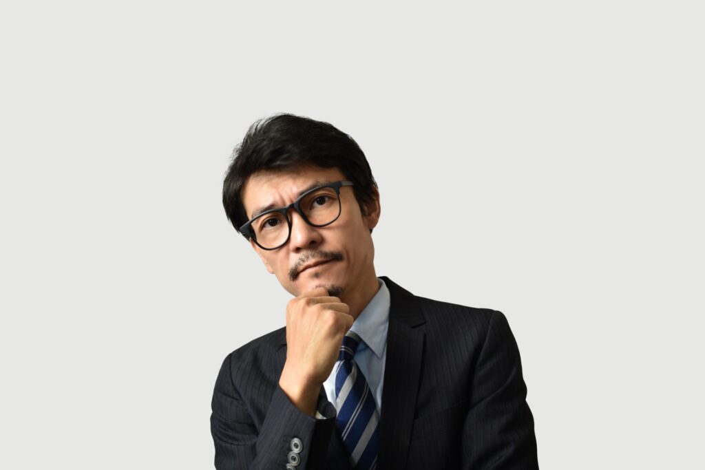 顎に手を当てるメガネのビジネスマン