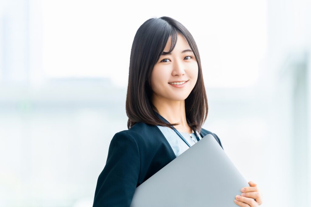 パソコン持って立つ女性