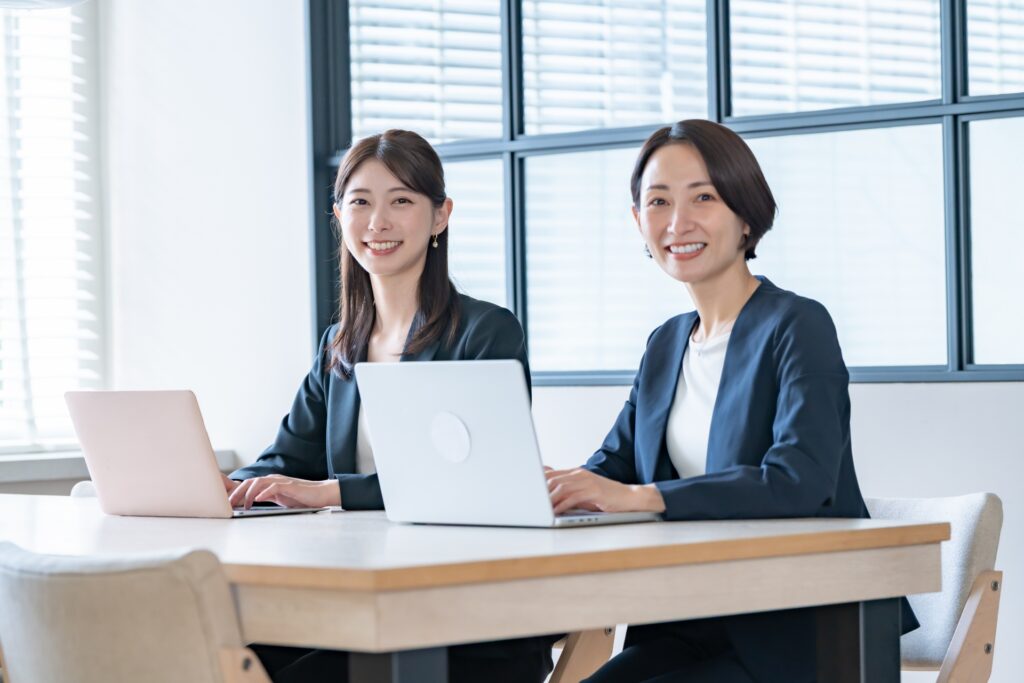 カメラ目線のスーツを着た女性二人