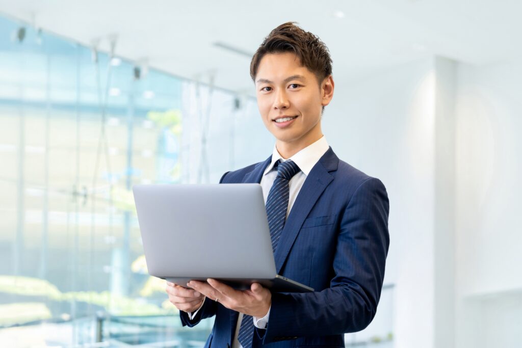 ノートパソコンを持つ笑顔のビジネスマン