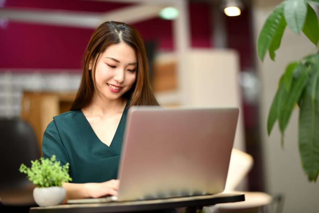 赤い背景の部屋でパソコンを操作する女性