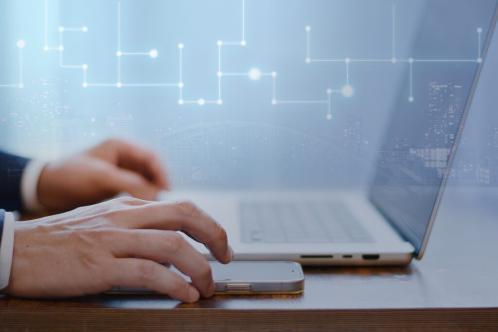 パソコンとスマホを操作するビジネスマン