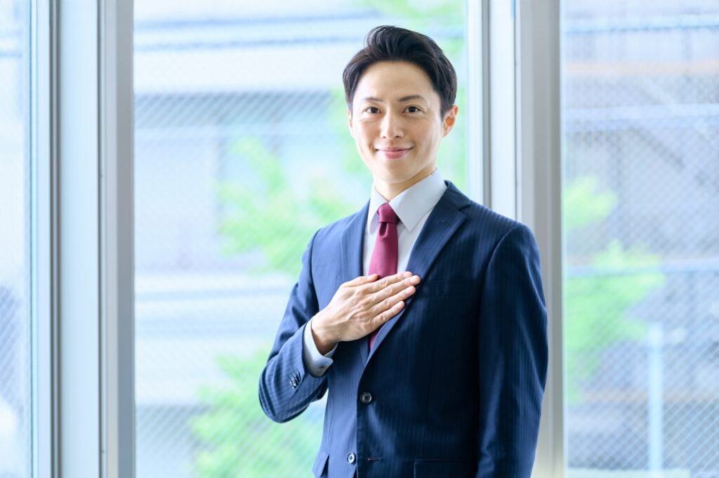 胸に手を当てる男性