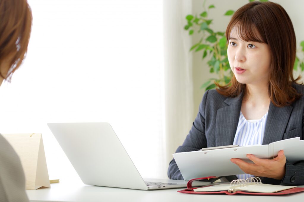 顧客と話し合いをするスーツ姿の女性